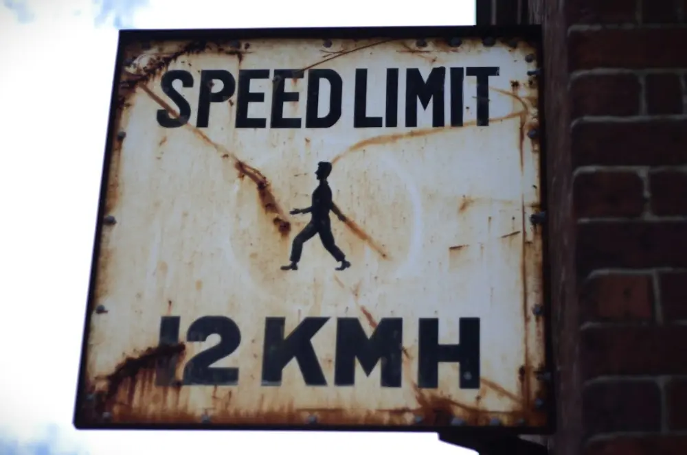 A rusted sign that says speed limit on it, illustrating speed and friction